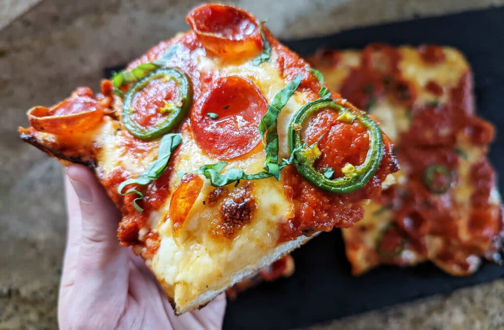 Slice of spicy detroit pizza