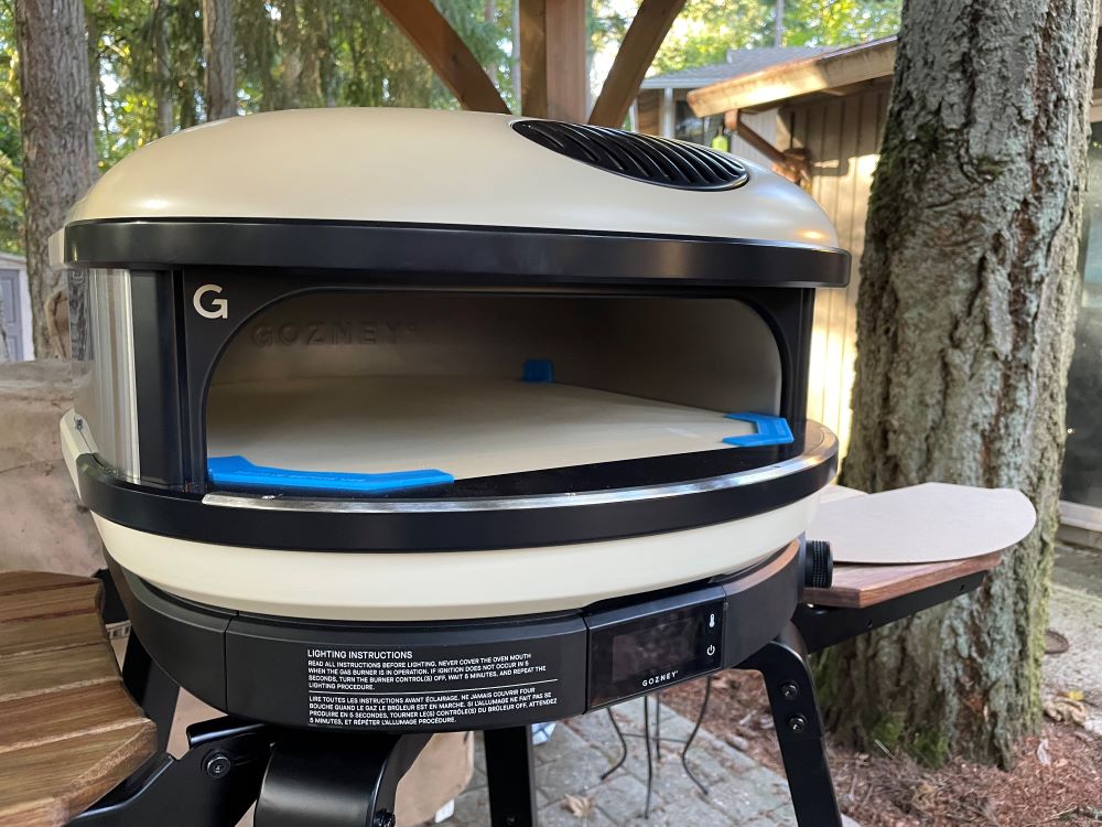 Unused Arc XL pizza oven in the woods with the protective packaging still on the stone.
