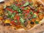 Hero shot of curry pizza with potatoes, carrots, red ginger, and cilantro