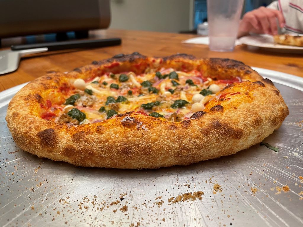 Ooni Volt 2 Review: A Premium Electric Pizza Oven Gets Even Better? Pizza Oven New York style pizza with pesto and mushrooms and a dark golden crust.