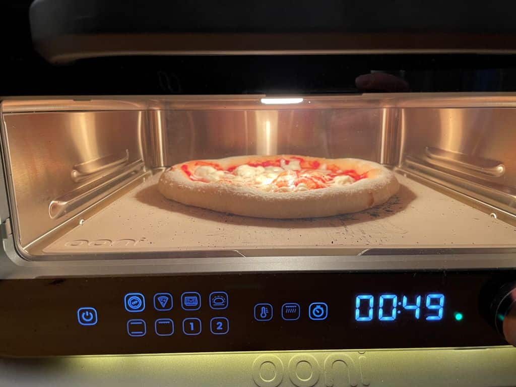 Ooni Volt 2 Review: A Premium Electric Pizza Oven Gets Even Better? Pizza Oven Cheese pizza cooking inside the Volt 2 pizza oven.