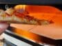 A slice of pizza in front of the Dome Gen 2.